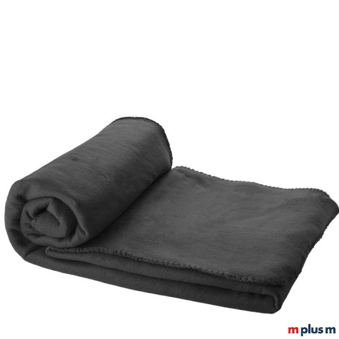 Die schwarze 'Huggy' Decke besteht aus weichem und bequemem Polarfleece. Ab einer Menge von 50 Stück können Sie die Decke bedrucken lassen
